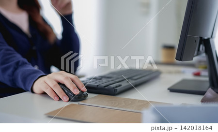 Asian woman furniture designer using computer mouse while working at modern office desk with copy space 142018164