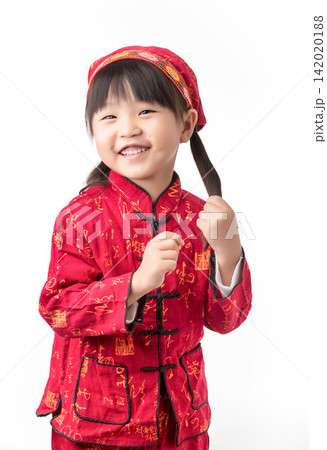Adorable little girl in traditional red Chinese clothes tilting head and touching her pigtail. Adorable little girl in traditional red Chinese clothes tilting head and touching her pigtail. 142020188