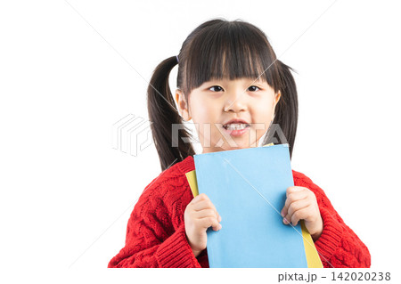 Proud East Asian child showing a small book with blank cover in studio. Proud East Asian child showing a small book with blank cover in studio. 142020238
