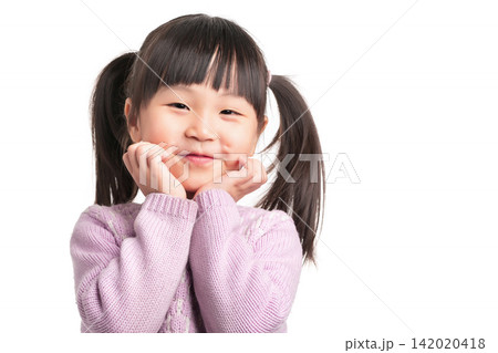 Adorable little preschool girl holding her cheeks with both hands smiling gently in studio. Adorable little preschool girl holding her cheeks with both hands smiling gently in studio. 142020418