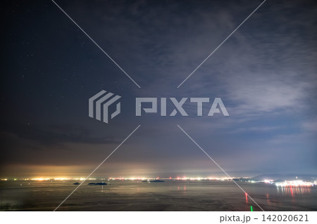 海上の遠景夜景と雲が広がる夜空 142020621