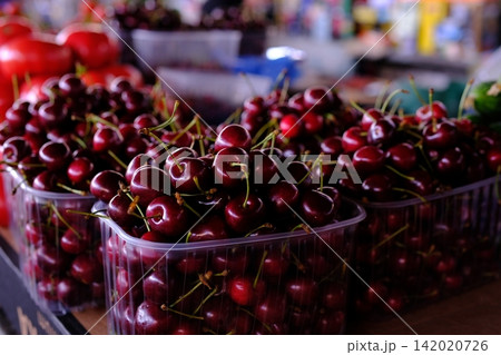 Fresh sweet cherries displayed at local farmers market, ripe summer fruit for healthy snacks, seasonal harvest, natural produce and colorful market food selection Fresh sweet cherries displayed at local farmers market, ripe summer fruit for healthy snacks, seasonal harvest, natural produce and colorful market food selection 142020726