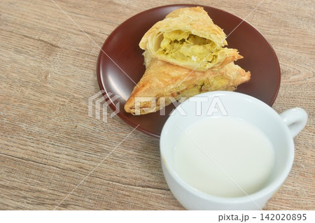 salty chicken curry pie on plate with fresh milk cup salty chicken curry pie on plate with fresh milk cup 142020895