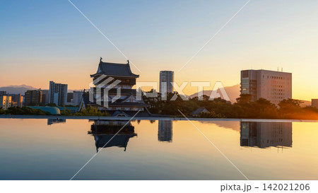 Kokura Castle with skyscraper reflection on pond at sunset, Kitakyushu Kokura Castle with skyscraper reflection on pond at sunset, Kitakyushu 142021206