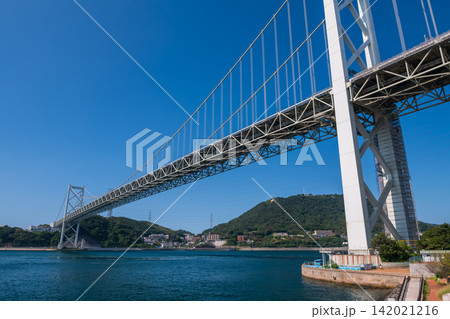 Iconic Kanmon Bridge by strait against blue sky, Kitakyushu, Fukuoka Iconic Kanmon Bridge by strait against blue sky, Kitakyushu, Fukuoka 142021216