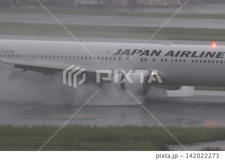 雨の滑走路に着陸する旅客機 エンジンの逆噴射の水煙 雨の滑走路に着陸する旅客機 エンジンの逆噴射の水煙 142022273