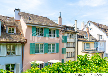 European Houses with Tiled Roofs, Dormer Windows and Lush Green. Old city architecture. Window with wooden shutters. Cityscape in Zurich Switzerland 142022839