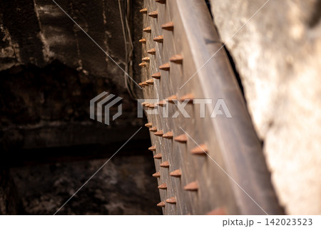 A close-up view of an intricate metal structure with long, dark spikes on an old A close-up view of an intricate metal structure with long, dark spikes on an old 142023523