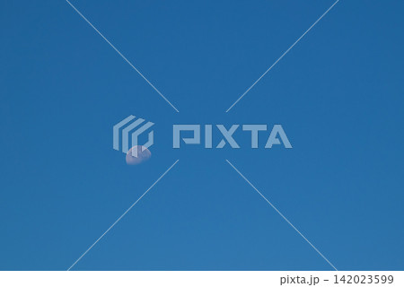 A faint crescent moon against a deep blue sky A faint crescent moon against a deep blue sky 142023599