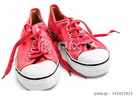 Crimson Canvas Sneakers with Untied Shoelaces on White Background Crimson Canvas Sneakers with Untied Shoelaces on White Background 142023923