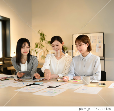 オフィスで打ち合わせをする3人の女性チーム オフィスで打ち合わせをする3人の女性チーム 142024180