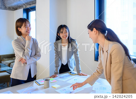 会議で資料を囲んで話し合う3人の女性ビジネスパーソン 142024205