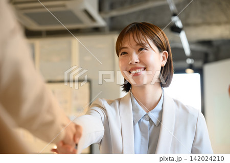 握手をする笑顔のビジネスウーマン 握手をする笑顔のビジネスウーマン 142024210
