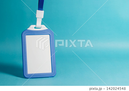 Vertical blank blue identity badge holder with lanyard on a bright cyan background, ideal for corporate branding mockups. High Quality Photo 142024548