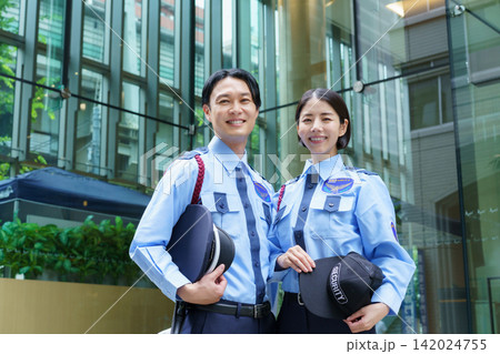 オフィスビルの前に立つ若い日本人男性警備員と女性警備員のポートレート オフィスビルの前に立つ若い日本人男性警備員と女性警備員のポートレート 142024755