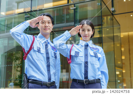 オフィスビルの前に立つ若い日本人男性警備員と女性警備員のポートレート オフィスビルの前に立つ若い日本人男性警備員と女性警備員のポートレート 142024758