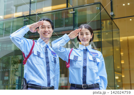 オフィスビルの前に立つ若い日本人男性警備員と女性警備員のポートレート オフィスビルの前に立つ若い日本人男性警備員と女性警備員のポートレート 142024759
