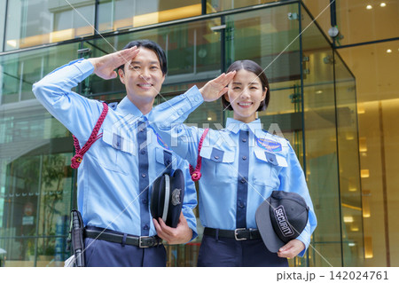 オフィスビルの前に立つ若い日本人男性警備員と女性警備員のポートレート オフィスビルの前に立つ若い日本人男性警備員と女性警備員のポートレート 142024761