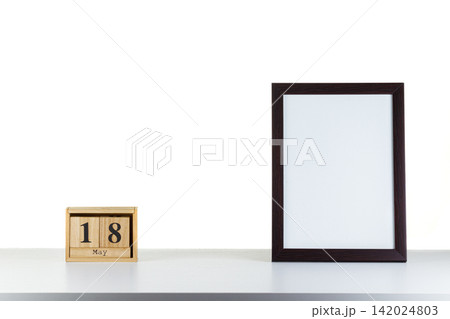 Wooden calendar 18 may with frame for photo on white table and background 142024803
