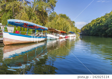 river with moored boats and rainforest river with moored boats and rainforest 142025114