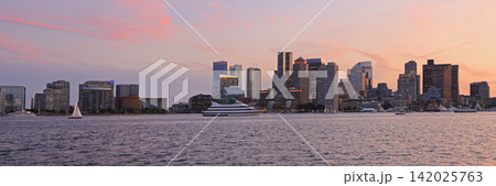 Boston skyline illuminated at dusk with Atlantic Ocean on the foreground, USA 142025763