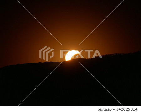 Partial solar eclipse above mountain silhouette - glowing crescent sun, astronomy, nature and cosmic phenomenon concept. Partial solar eclipse above mountain silhouette - glowing crescent sun, astronomy, nature and cosmic phenomenon concept. 142025814
