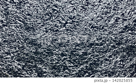 crumpled aluminum foil texture shining silver creases over dark shadows for futuristic packaging and web design backdrop crumpled aluminum foil texture shining silver creases over dark shadows for futuristic packaging and web design backdrop 142025855