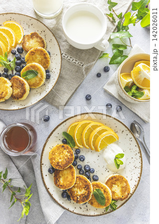 Delicious breakfast with curd fritter, ricotta fritter or cottage cheese pancakes on ceramic plate. Gourmet healthy delicious morning breakfast Delicious breakfast with curd fritter, ricotta fritter or cottage cheese pancakes on ceramic plate. Gourmet healthy delicious morning breakfast 142026011