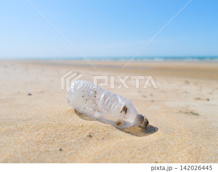 Plastic bottle on the beach. Plastic trash buried in the sand. Plastic bottle on the beach. Plastic trash buried in the sand. 142026445