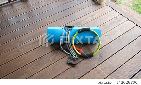 Sport Home exercise equipment. Efficient workout routine. Fitness gear placed for home fit. Yoga mat, roller, dumbbells on room floor ready for recovery session. Personal inventory for weight loss Sport Home exercise equipment. Efficient workout routine. Fitness gear placed for home fit. Yoga mat, roller, dumbbells on room floor ready for recovery session. Personal inventory for weight loss 142026800