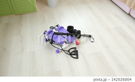 Sport Home exercise equipment. Efficient workout routine. Fitness gear placed for home fit. Yoga mat, roller, dumbbells on room floor ready for recovery session. Personal inventory for weight loss Sport Home exercise equipment. Efficient workout routine. Fitness gear placed for home fit. Yoga mat, roller, dumbbells on room floor ready for recovery session. Personal inventory for weight loss 142026804