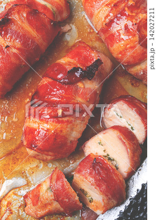 baked chicken breast, wrapped in bacon, on a baking tray. in the home kitchen.close-up. 142027211