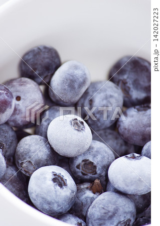 Macro shot of frozen fresh blueberries with hoarfrost frost layer in a bowl Macro shot of frozen fresh blueberries with hoarfrost frost layer in a bowl 142027223