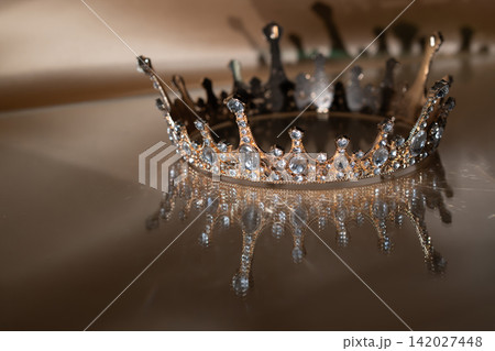 Luxury Golden Crown with Crystal Details and Reflection on Brown Background. Royal Elegance. 142027448