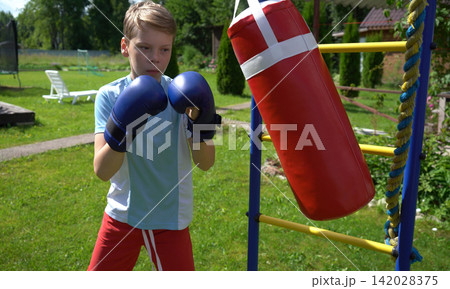 Preteen kid doing dynamic fitness training and cardio exercise outdoors using colorful playground installations to boost stamina and motor skills growth Preteen kid doing dynamic fitness training and cardio exercise outdoors using colorful playground installations to boost stamina and motor skills growth 142028375