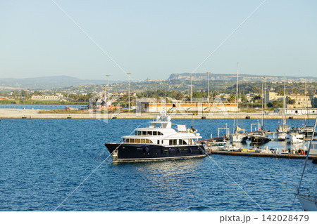 Luxury motor yacht docked in serene harbor clear summer day weather in resort country side settlement Luxury motor yacht docked in serene harbor clear summer day weather in resort country side settlement 142028479