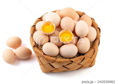 fresh farm eggs in woven basket with broken egg yolk fresh farm eggs in woven basket with broken egg yolk 142030062