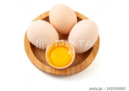 fresh farm eggs in woven basket with broken egg yolk fresh farm eggs in woven basket with broken egg yolk 142030063