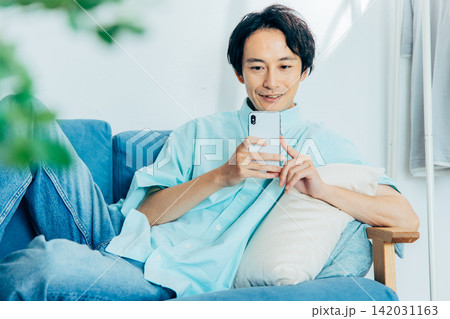 スマホを見る若い男性 142031163