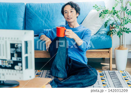 自宅でくつろぐ若い男性 142031209