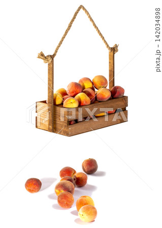 Harvest ripe peaches in a wooden box on a white background 142034898