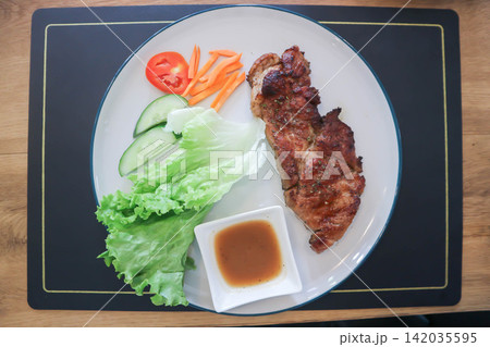 pork steak or grilled pork and salad or pork chop and vegetable 142035595