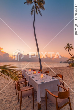 Romantic candlelit beach dinner table glowing pastel dusk lone palm calm tropical sea setup. Luxury honeymoon travel paradise scenic. Exotic couples getaway decor wallpaper Romantic candlelit beach dinner table glowing pastel dusk lone palm calm tropical sea setup. Luxury honeymoon travel paradise scenic. Exotic couples getaway decor wallpaper 142036116