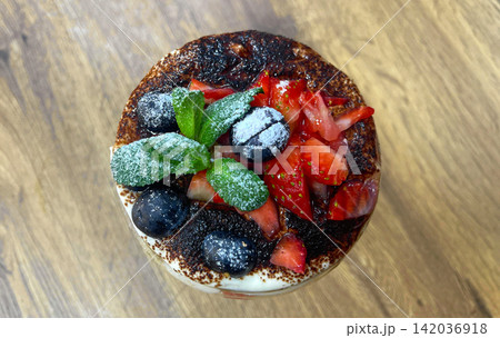 a dessert with a strawberry and blackberries on top a dessert with a strawberry and blackberries on top 142036918