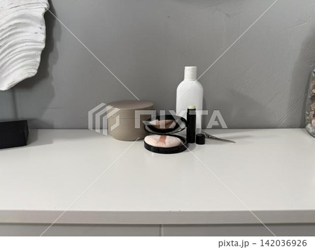 a white dresser with a mirror and a cosmetics set 142036926