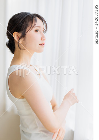 ビューティーイメージ  窓辺に立つ若い女性 142037395