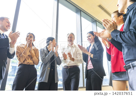 Group of multi-ethnic business colleagues standing in circle and brainstorming about new campaign, celebrating work success. Group of multi-ethnic business colleagues standing in circle and brainstorming about new campaign, celebrating work success. 142037651