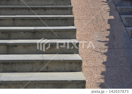 Outdoor concrete stairs with a stone stroller ramp and geometric shadows Outdoor concrete stairs with a stone stroller ramp and geometric shadows 142037873