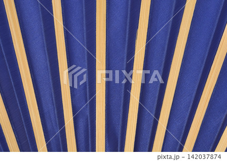 Blue folding hand fan with bamboo ribs close up Blue folding hand fan with bamboo ribs close up 142037874