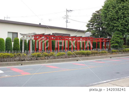 住宅街の道路脇に佇む伝統的な千本鳥居の風景 住宅街の道路脇に佇む伝統的な千本鳥居の風景 142038241